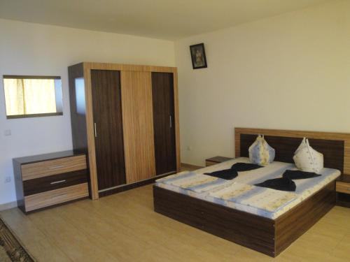 a bedroom with a bed and a wooden cabinet at Къща за гости Уют in Sveti Vlas