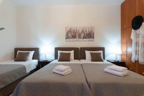 a bedroom with two beds with towels on them at Virvilis Apartments in Sivota