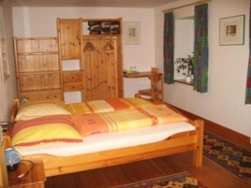 ein Schlafzimmer mit einem Holzbett in einem Zimmer in der Unterkunft Pension Sonne in Rickenbach