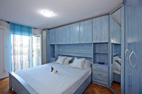 a bedroom with a large bed with blue cabinets at Apartment Samanta in Supetar
