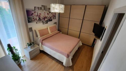 a small bedroom with a bed and a television at Appartamento nel cuore di Porto Azzurro in Porto Azzurro