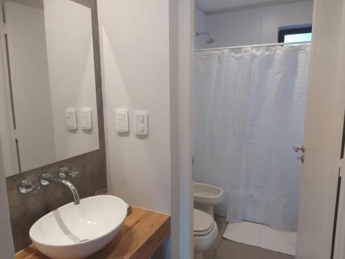 uma casa de banho branca com um lavatório e um WC em EXCEPCIONAL DEPARTAMENTO EN MAIPÚ- Ruta del vino 4 personas!! em Maipú