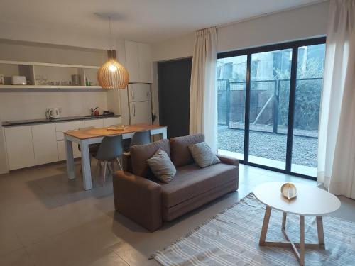 a living room with a couch and a table at EXCEPCIONAL DEPARTAMENTO EN MAIPÚ- Ruta del vino 4 personas!! in Maipú