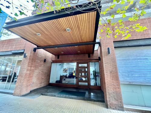a brick building with a wooden ceiling at Apartamentos City Centro Los Leones in Santiago