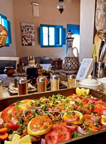 a table topped with a pizza with tomatoes and vegetables at Taghazout Ocean View in Taghazout