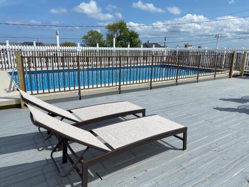 una panchina seduta su una terrazza accanto alla piscina di Ways Motel a Hampton Beach