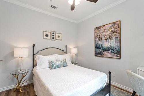 a white bedroom with a bed and two lamps at The Benjamin I - 2022 Built Luxury Retreat with Backyard Paradise with Hot Tub Outdoor Movie Screen Dock & Boat Rental in Gun Barrel City