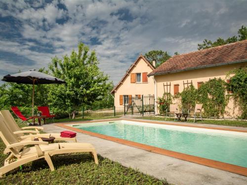 une maison avec une piscine et un parasol dans l'établissement Gite LEysalle, à Monbazillac