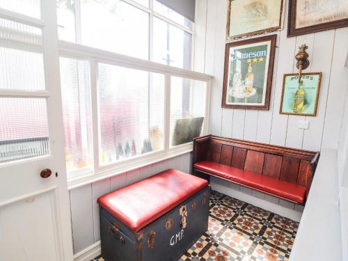 a red bench in a room with a window at The Merchant's Store in Kilrush