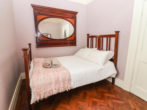 a cat laying on a bed in front of a mirror at The Merchant's Store in Kilrush