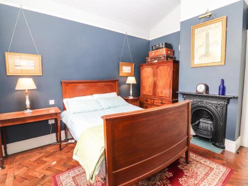 a bedroom with a bed and a desk and a fireplace at The Merchant's Store in Kilrush