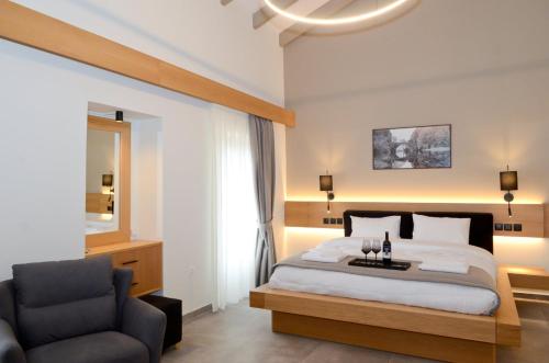 a bedroom with a large bed and a chair at Roloi suites in Nafpaktos