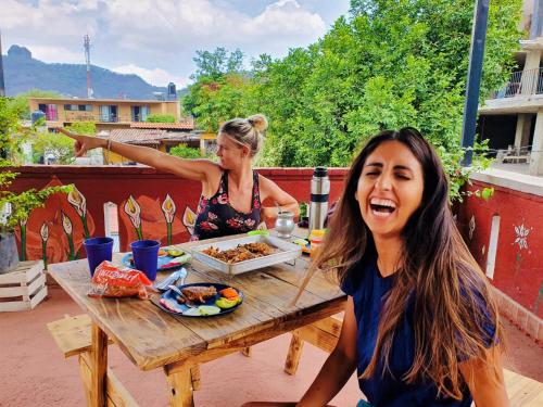 dos mujeres sentadas en una mesa comiendo comida en Mi Atardecer en Tepoz, Hostal en Tepoztlán