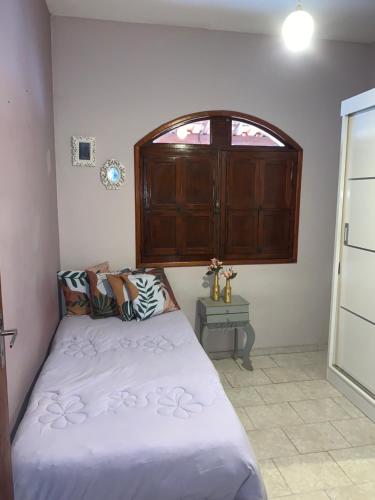 a bedroom with a bed and an open window at Casa dos Martins - Próximo ao Autódromo Potenza e Cachoeira Arco Iris in Lima Duarte