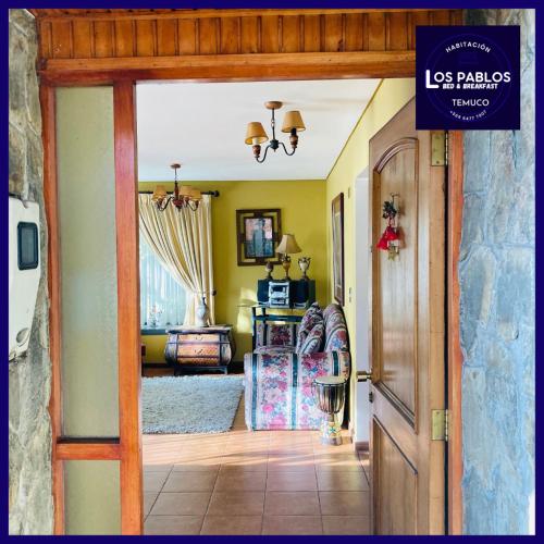 an open door to a living room with a couch at B&B Los Pablos Temuco in Temuco