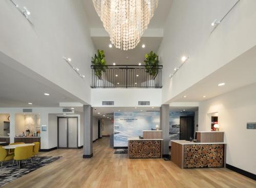 an office lobby with a chandelier and a waiting area at La Quinta Inn & Suites by Wyndham Santa Cruz in Santa Cruz