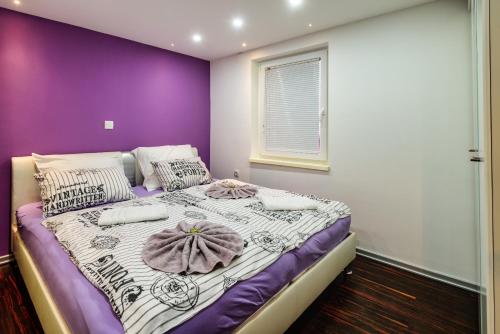 - une chambre violette et blanche avec un grand lit dans l'établissement MaJo Apartma Punta, à Piran