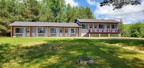 a large house with a large lawn in front of it at Fair Isle Motel & The Nest in Whycocomagh