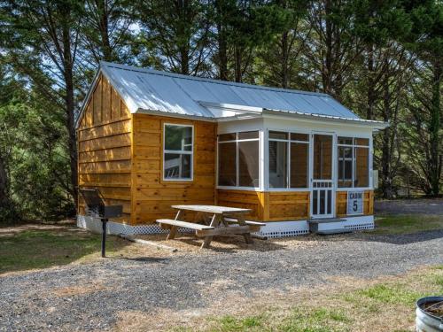 a wooden cabin with a picnic table in front of it at Beach Bum West-O Cabins in Ocean City