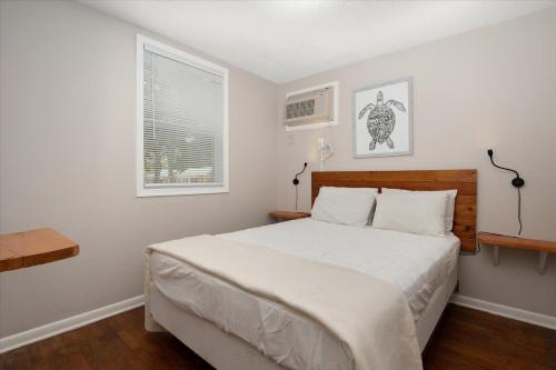 a bedroom with a large bed and two windows at Beach Bum West-O Cabins in Ocean City