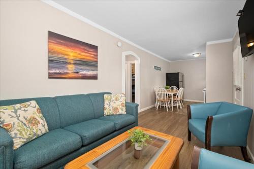a living room with a blue couch and a table at Beach Bum West-O Cabins in Ocean City
