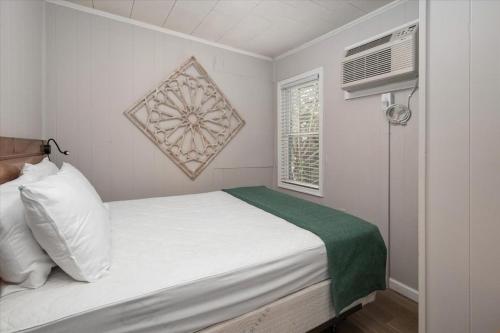 a small bedroom with a white bed and a window at Beach Bum West-O Cabins in Ocean City