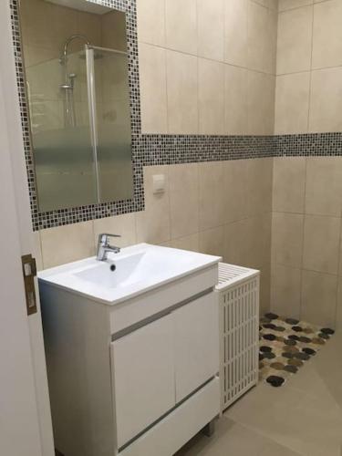 a white bathroom with a sink and a mirror at Casa de Férias in Villa Nogueira