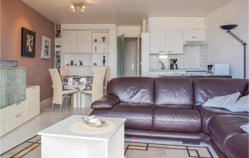 a living room with a brown leather couch and a kitchen at Residentie Zon & Zee Ref 20 in Ostend
