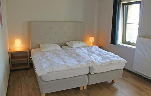 ディクスムイデにあるNice Apartment In Diksmuide With 1 Bedrooms And Wifiのベッド1台(テーブル2つにランプ2つ付)