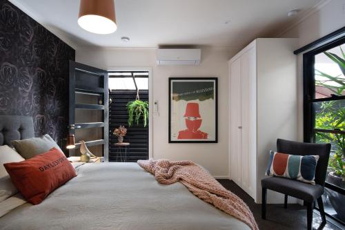 a bedroom with a large bed and a chair at East St 3 in Daylesford