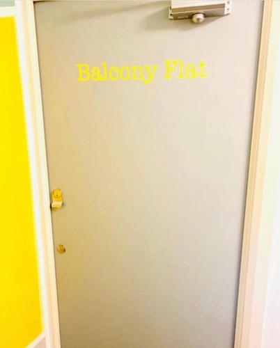 a door with a yellow flat sign on it at St Ives Balcony Flat in St Ives