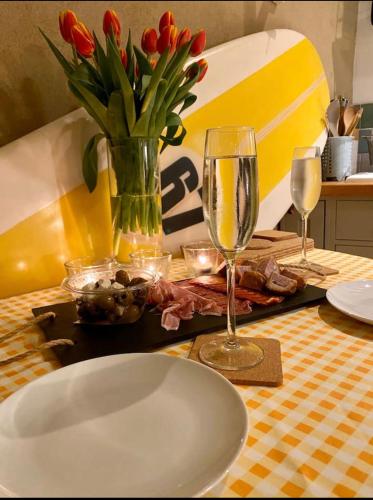 a table with a white plate and two wine glasses at St Ives Balcony Flat in St Ives