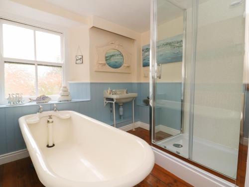 uma casa de banho com uma banheira, um chuveiro e um lavatório. em St Edmunds House em Bedale