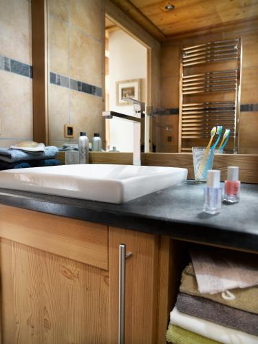 La salle de bains est pourvue d'un lavabo blanc sur un comptoir. dans l'établissement Résidence Les Alpages De Champagny, à Champagny-en-Vanoise