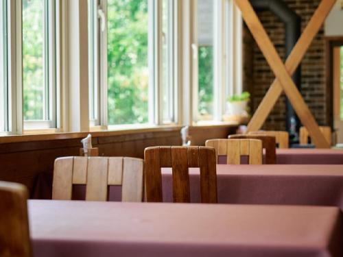a table and chairs in a restaurant with windows at Pension Asanebou in Minakami