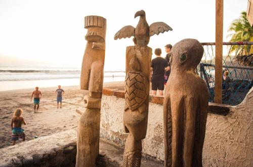a group of wooden posts on the beach at Olas Permanentes El Zonte in El Zonte