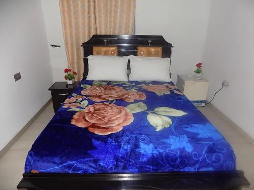 Una cama con una colcha azul con flores. en Great Secured 1Bedroom Service Apartment ShortLet-FREE WIFI - Peter Odili RD - N29,000, en Port Harcourt