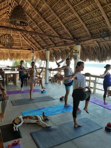 a group of people doing yoga on the beach at Olas Permanentes El Zonte in El Zonte