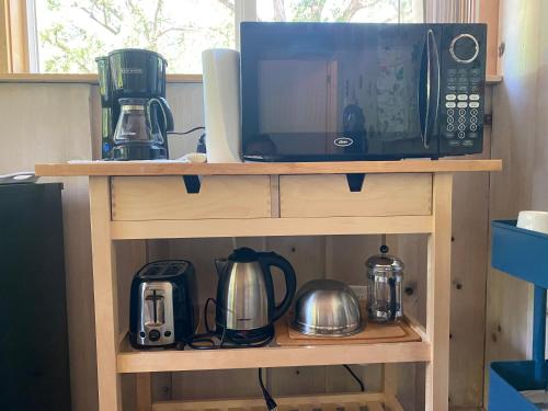 a microwave sitting on top of a wooden shelf at Private 1 Bd near Yosemite and Bass lake in Oakhurst