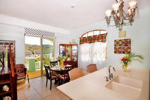 Il dispose d'une cuisine avec un évier et d'une salle à manger avec une table. dans l'établissement BeachFront Villa, à Gros Islet