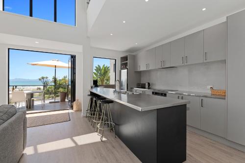 a kitchen and living room with a view of the ocean at Harnifin - Langs Beach Holiday Home in Langs Beach