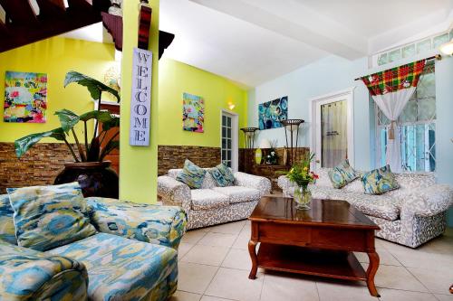 a living room with two couches and a table at BeachFront Villa in Gros Islet