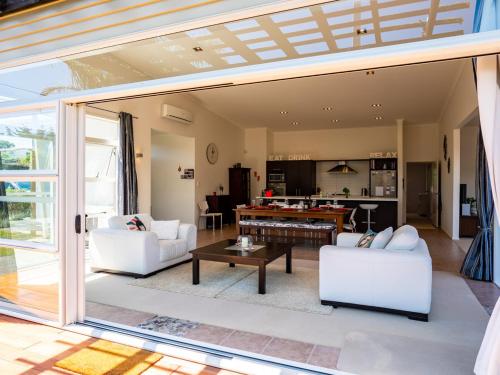 a living room with a large sliding glass door at Magnifique - Mangawhai Holiday Home in Mangawhai