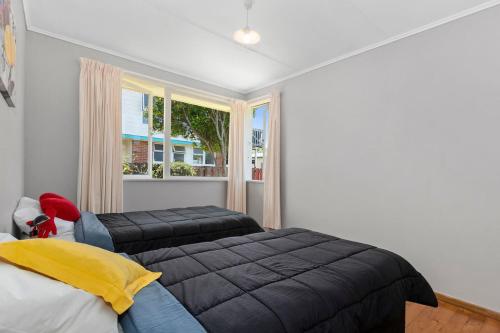a bedroom with two beds and a window at Kulukulu - Ruakaka Holiday Home in Ruakaka