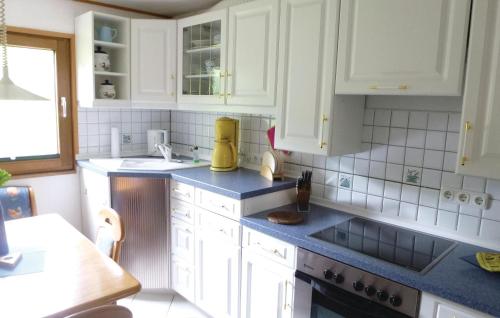 uma cozinha com armários brancos e bancadas azuis em Lovely Home In Wolfshagen With House A Mountain View em Wolfshagen