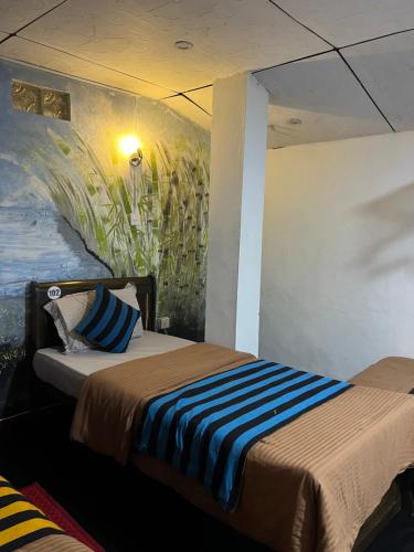 een slaapkamer met 2 bedden en een schilderij aan de muur bij Noname Hostel And Cafe in Ella
