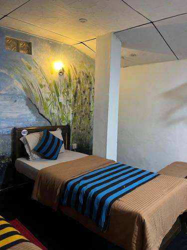 a bedroom with two beds and a painting on the wall at Noname Hostel And Cafe in Ella