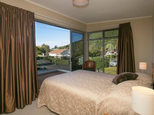 um quarto com uma cama e uma grande janela em Perfect Position - Motuoapa Holiday Home em Turangi