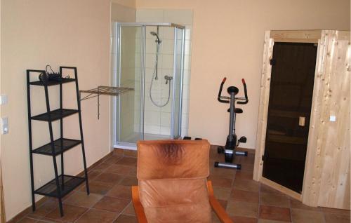 a room with a gym with a shower and a chair at Awesome Home In Karwesee With Sauna in Karwesee