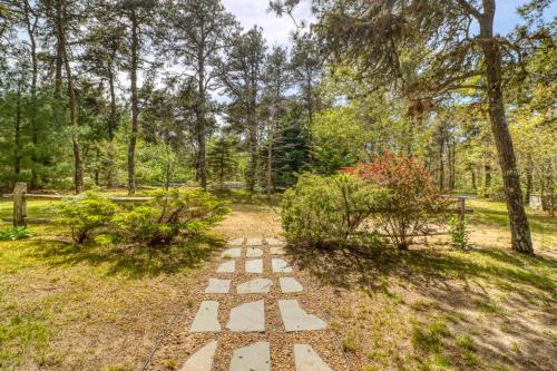 a pathway in a garden with trees in the background at Pretty on Prada in Edgartown